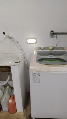 a washing machine in a room with a toilet at Privacidade com Hidro, piscina em casa, garagem, tudo privativo, 2 banheiros, churrasqueira e pátio amplo exclusivos, insira 3 hóspedes e abrimos 2 quartos com ar, já 5 hóspedes para 3 quartos com ar in Sorriso