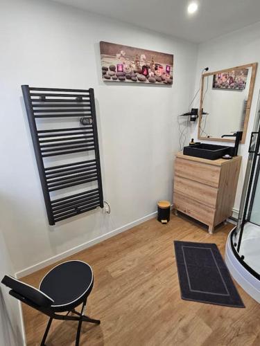 Cette chambre comprend un miroir, une chaise et une commode. dans l'établissement Studio avec jardin Rosendael proche plage, à Dunkerque