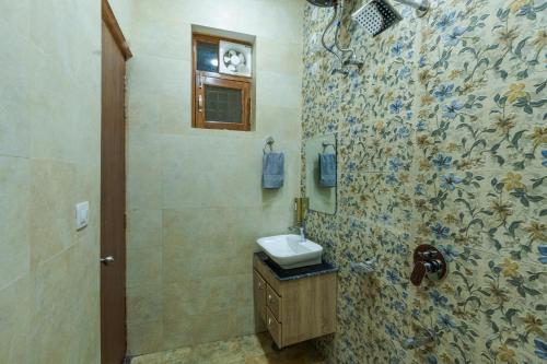 La salle de bains est pourvue d'un lavabo et d'une douche. dans l'établissement Dhruva - Lux 3BHK in Dun, à Dehradun