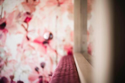 a room with a mirror and a wall with flowers at Pension Haus Tirol in Laion