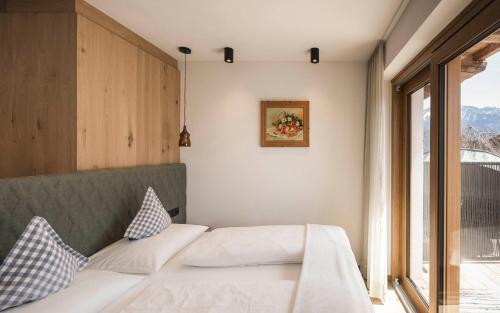 a bedroom with a bed and a window at Pension Haus Tirol in Laion