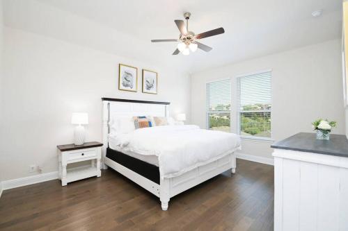 a white bedroom with a bed and a ceiling fan at Texas Luxury Home 3 in San Antonio