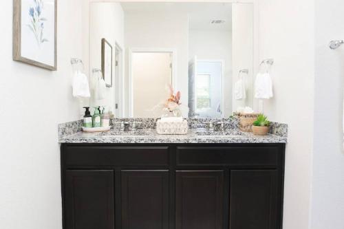 baño con lavabo negro y espejo en Texas Luxury Home 3, en San Antonio