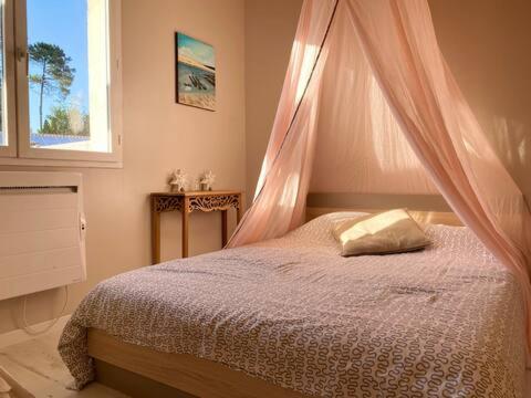 une chambre avec un lit avec moustiquaire dans l'établissement Maison de vacances Arès, Bassin d'Arcachon, à Arès