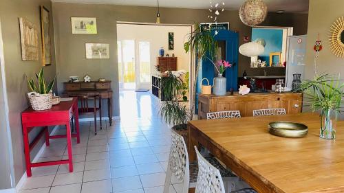 une cuisine et une salle à manger avec une table et des chaises rouges dans l'établissement Maison de vacances Arès, Bassin d'Arcachon, à Arès
