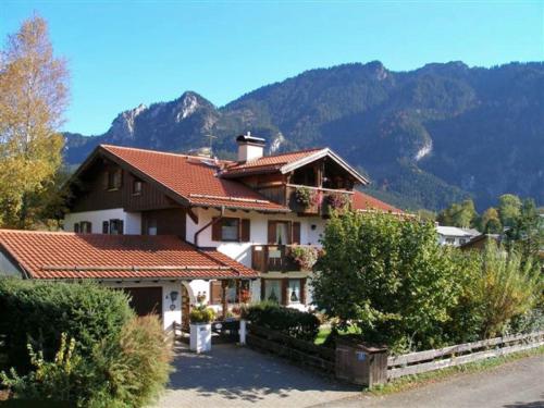 a large house with a mountain in the background at Ferienwohnung Claudia in Oberammergau