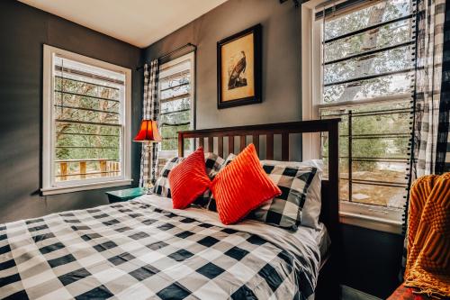 een slaapkamer met een bed met rode kussens bij 2BR 3BDs Historical TREE HOUSE on UT Campus in Austin