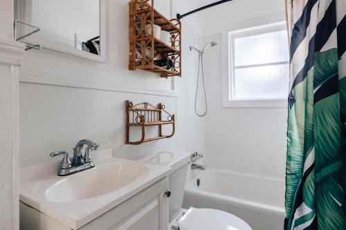 een witte badkamer met een wastafel en een toilet bij 2BR 3BDs Historical TREE HOUSE on UT Campus in Austin