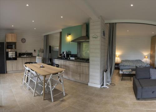 a kitchen and living room with a table and a couch at L'Eden des Grisons in Le Sauze-du-lac