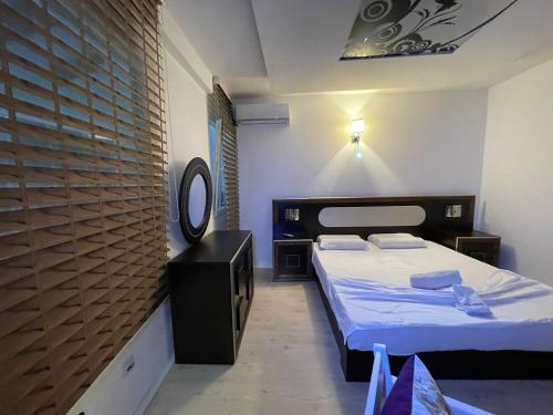 um pequeno quarto com 2 camas e um espelho em Deni house em Prizren