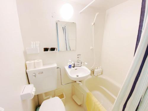 a white bathroom with a sink and a toilet at 新大阪駅徒歩30秒ポケットwifi貸出無料, 30s walk to Shinosaka Station, Umeda 6 mins, Kyoto 25 mins, Early Check in in Osaka