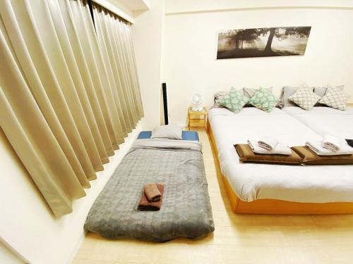 a bedroom with two twin beds and a window at 新大阪駅徒歩30秒ポケットwifi貸出無料, 30s walk to Shinosaka Station, Umeda 6 mins, Kyoto 25 mins, Early Check in in Osaka