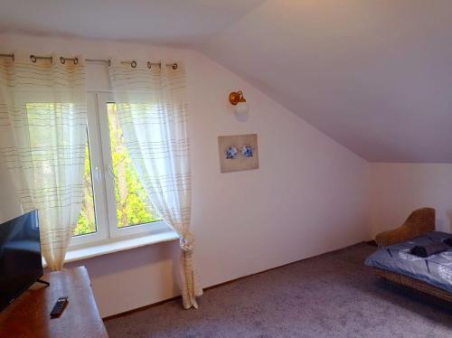 a attic room with a window and a bed at Gdańsk tanie noclegi pokój nr 10 1-2 osobowy z łazienką na korytarzu in Gdańsk