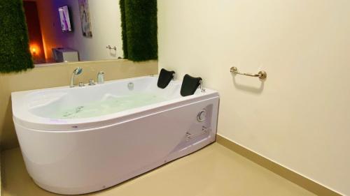 a white bathroom with a sink and a mirror at Bellavista Loft Jacuzzi & Balcón in Guayaquil