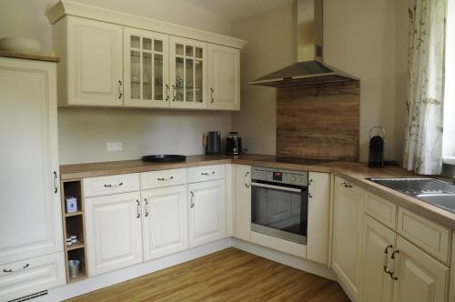 a kitchen with white cabinets and a stove top oven at das stille Paradies in Ledenitzen
