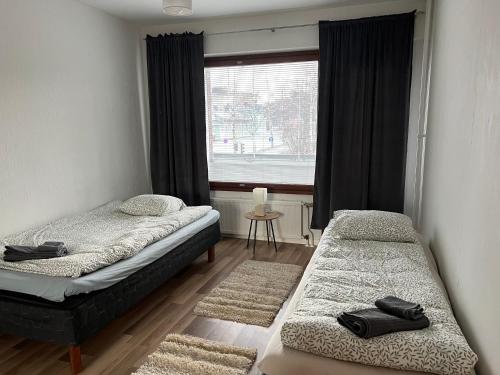 - une chambre avec 2 lits et une fenêtre dans l'établissement Apartment Tehtaankatu, à Kokkola