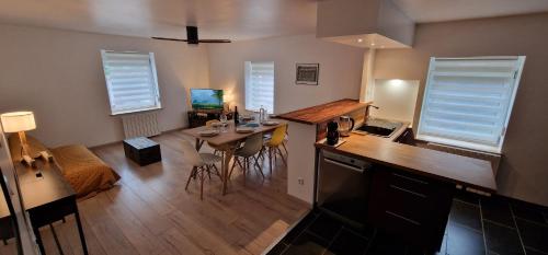 eine Küche und ein Wohnzimmer mit einem Tisch und Stühlen in der Unterkunft Bel appartement rénové avec de beaux volumes in Flavigny-sur-Moselle