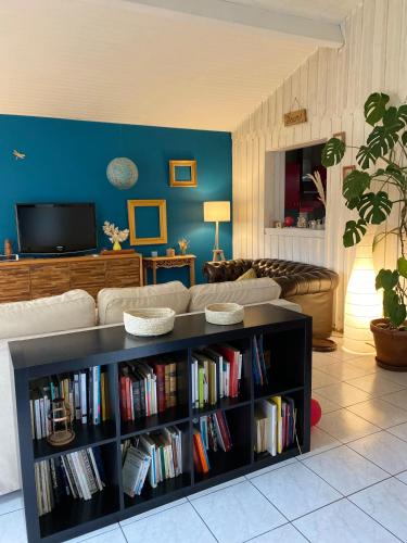 un salon avec une étagère remplie de livres dans l'établissement Maison de vacances Arès, Bassin d'Arcachon, à Arès