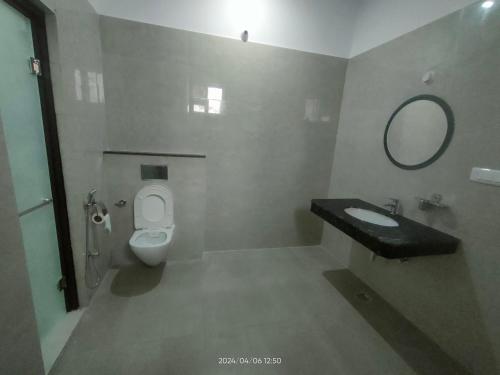 a bathroom with a toilet and a sink and a mirror at Executive House in Lucknow