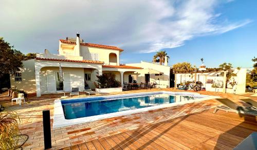a swimming pool in front of a house at Fantastic villa with panoramic coastal & sea views in Estói