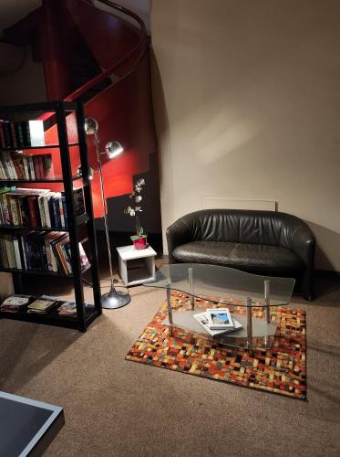 a living room with a couch and a glass table at The Originals City, Hôtel Le Forum, Strasbourg Nord in Schiltigheim