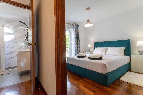 a bedroom with a bed with a blue headboard at Mónaco Nest in Ponta Delgada