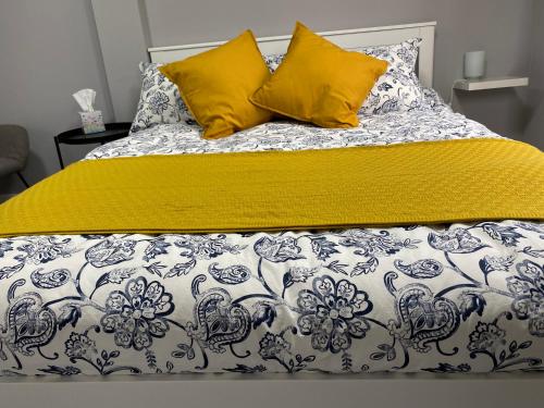 een bed met een gele deken en kussens erop bij Adorable 1 bedroom guesthouse in Burford