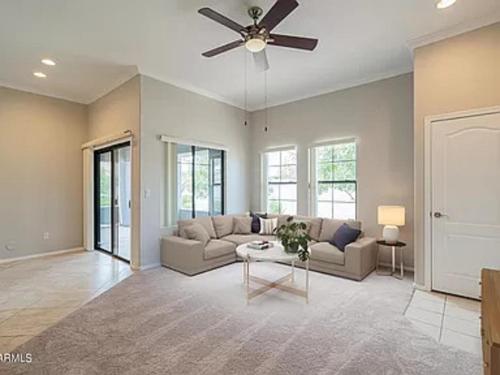 Lanret Home في Chandler: غرفة معيشة مع أريكة ومروحة سقف
