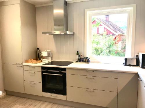 a white kitchen with a sink and a window at Villa Holmen 2 in Balestrand