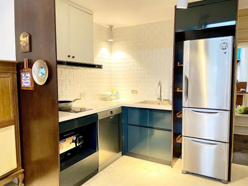 uma cozinha com armários azuis e um frigorífico de aço inoxidável em Bu Studio Hồ Hoàn Kiếm em Hanói