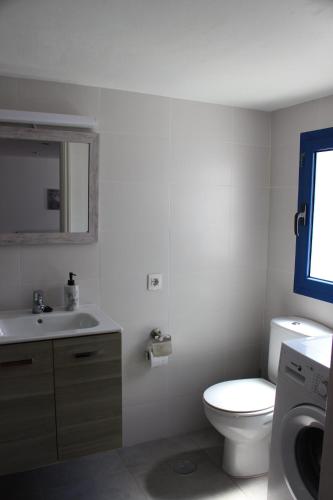 een witte badkamer met een toilet en een wastafel bij Casa Noah Famara in Famara