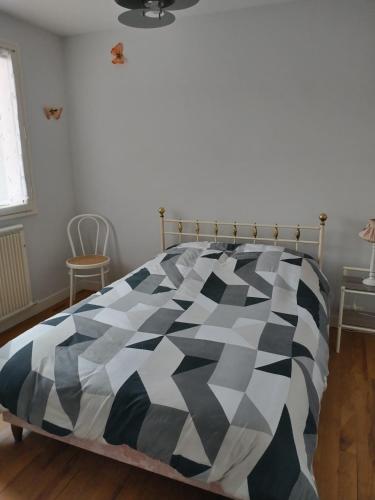 - une chambre avec une couette en noir et blanc sur un lit dans l'établissement La maison de Paulette, à Saint-Valery-sur-Somme