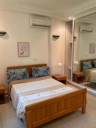 sypialnia z dużym łóżkiem i lustrem w obiekcie APPHIA SERVICES w mieście Pointe-Noire