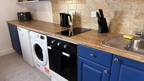a kitchen with a sink and a washing machine at Studio apartment - The Sapphire 