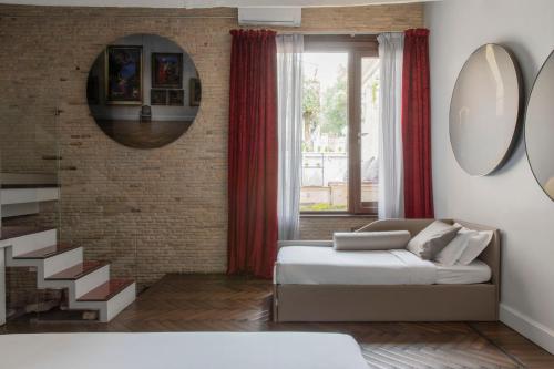 sala de estar con cama y pared de ladrillo en BDB Rooms Margutta, en Roma