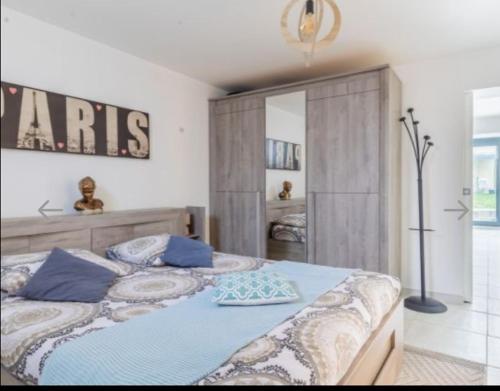 una camera da letto con un grande letto con cuscini blu di Élégant Appartement Calme et Spacieux avec Jardin a Choisy-le-Roi