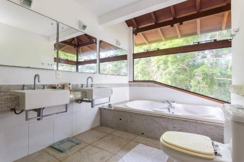uma casa de banho com uma banheira, um lavatório e um WC. em Mansão Luxury Alto da Brava em Búzios
