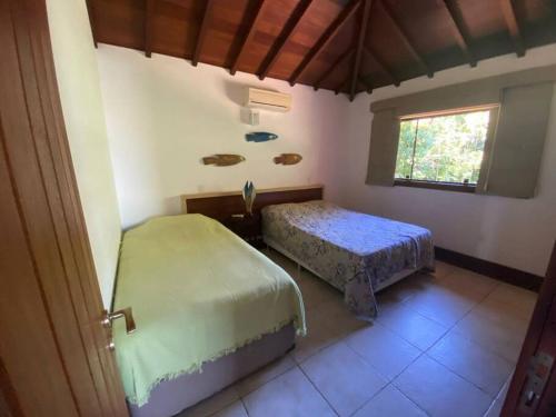 a bedroom with two beds and fish on the wall at Mansão Luxury Alto da Brava in Búzios