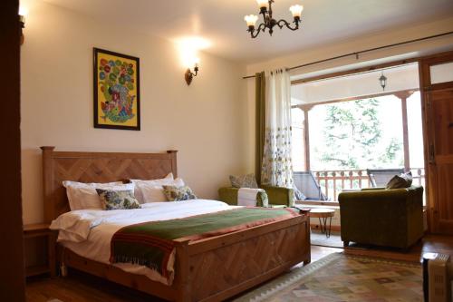 A bed or beds in a room at Kudrat - A Boutique Homestay- Tirthan Valley