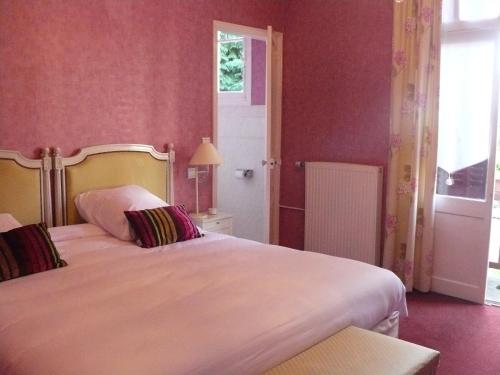 a bedroom with two beds with pink walls at La Villa Bois Joli HOTEL RESTAURANT in Bagnoles de l'Orne