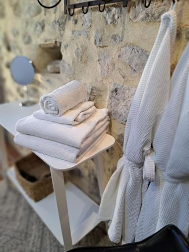 西斯特隆的住宿－Hôtel Le Patio de Sophie，一堆毛巾坐在一张白色的桌子上