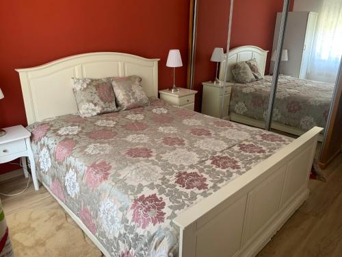 a bedroom with a large bed with a floral blanket at Beautiful 1-Bed Apartment in Aldeia de Paio Pires in Aldeia de Paio Pires