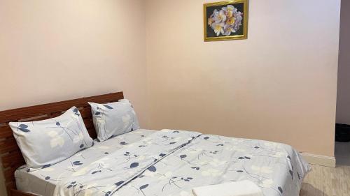 a bedroom with a bed and a picture on the wall at ที่พักสกลนครกรีนเฮ้าส์รีสอร์ท in Ban Na Oi