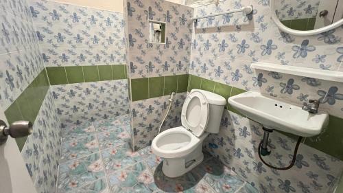 ein Bad mit einem WC und einem Waschbecken in der Unterkunft ที่พักสกลนครกรีนเฮ้าส์รีสอร์ท in Ban Na Oi
