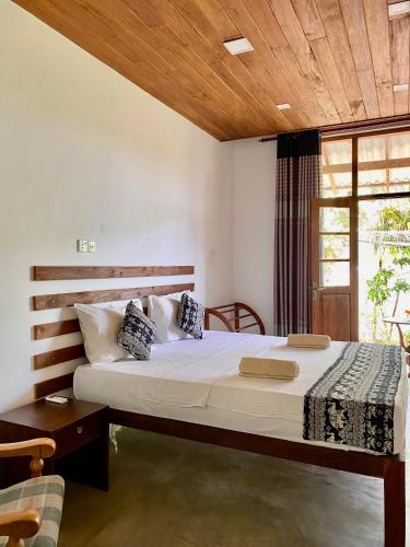 a bedroom with a large bed with a wooden ceiling at The Dale Mirissa in Mirissa