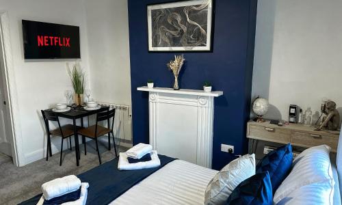 a bedroom with a bed and a table with a chair at Studio apartment - The Sapphire 