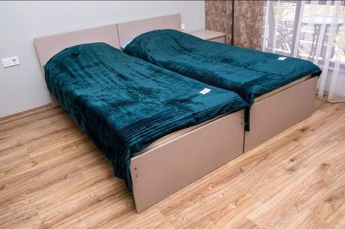 a bed with a green blanket on it in a room at Hotel Luka in Ureki