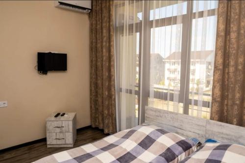a bedroom with a bed and a window with a tv at Hotel Luka in Ureki