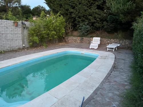- une piscine avec un banc et une chaise dans la cour dans l'établissement Casa Monte, à Monte Hermoso
