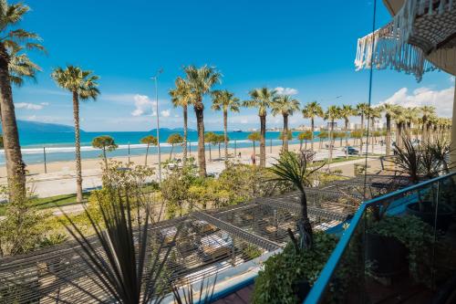 vistas a la playa y a las palmeras desde un edificio en Mustafa Suites, en Vlorë